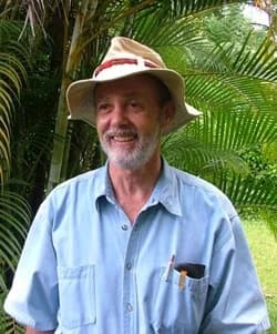 Jack Ewing seated at base of large kapok/ceiba tree.